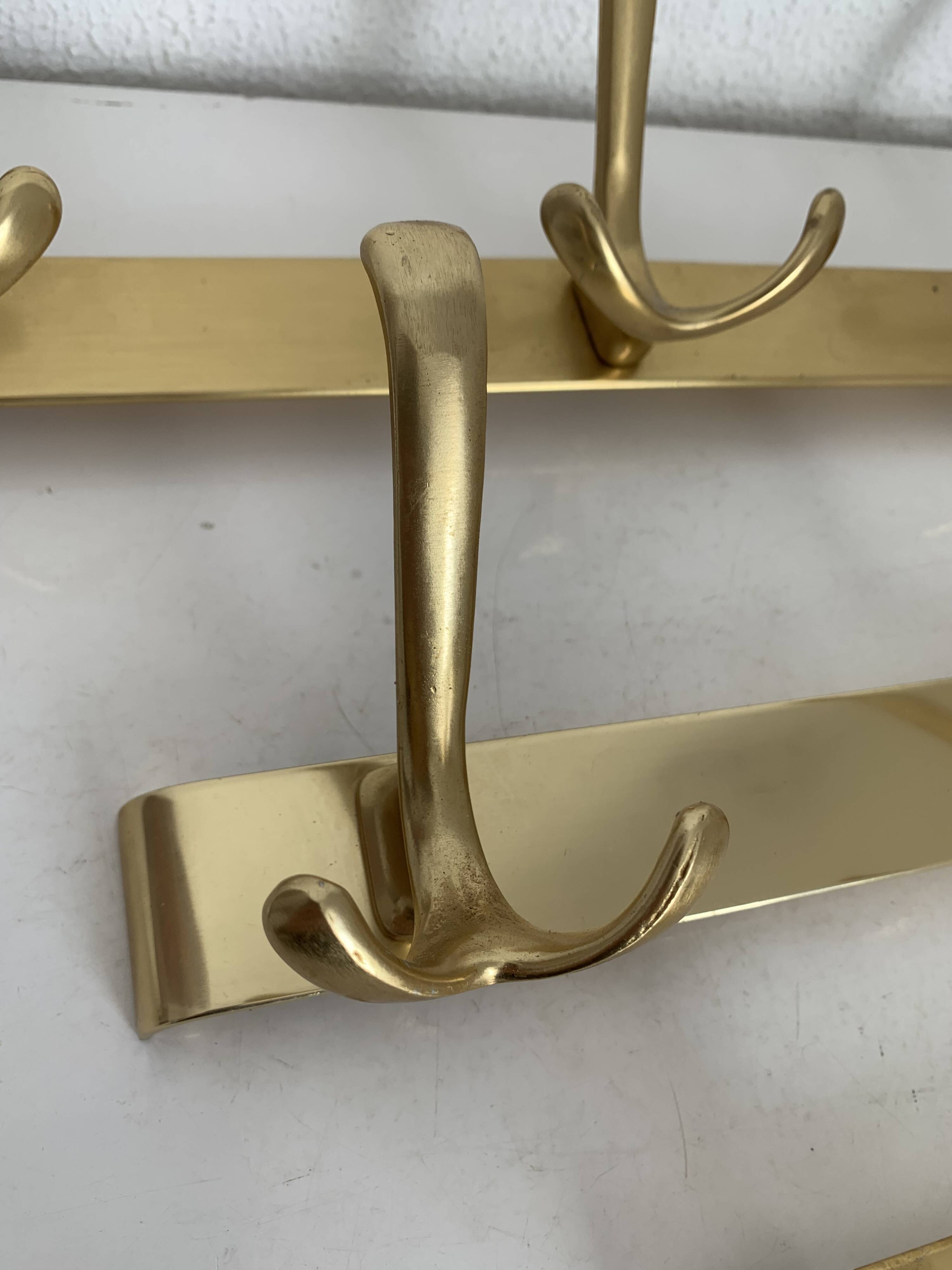Three vintage 1960s gold coat racks with 4, 3 and 2 hooks