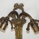 Double wall light in bronze in French Rococo style with white glass shades featuring patterns.