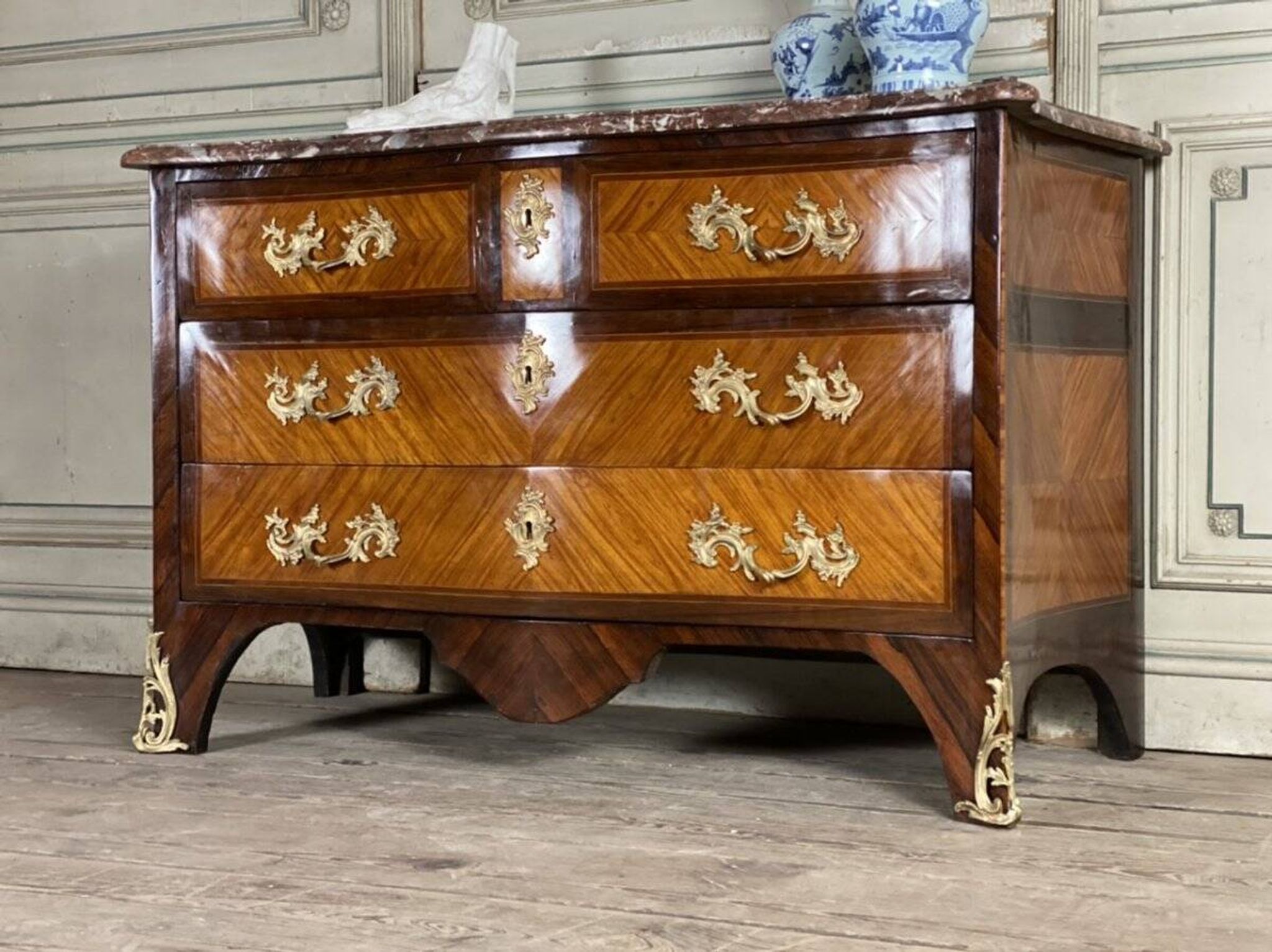 Louis XV style commode in rosewood and palisander veneer, gilt bronze mounts, and Rance marble top.