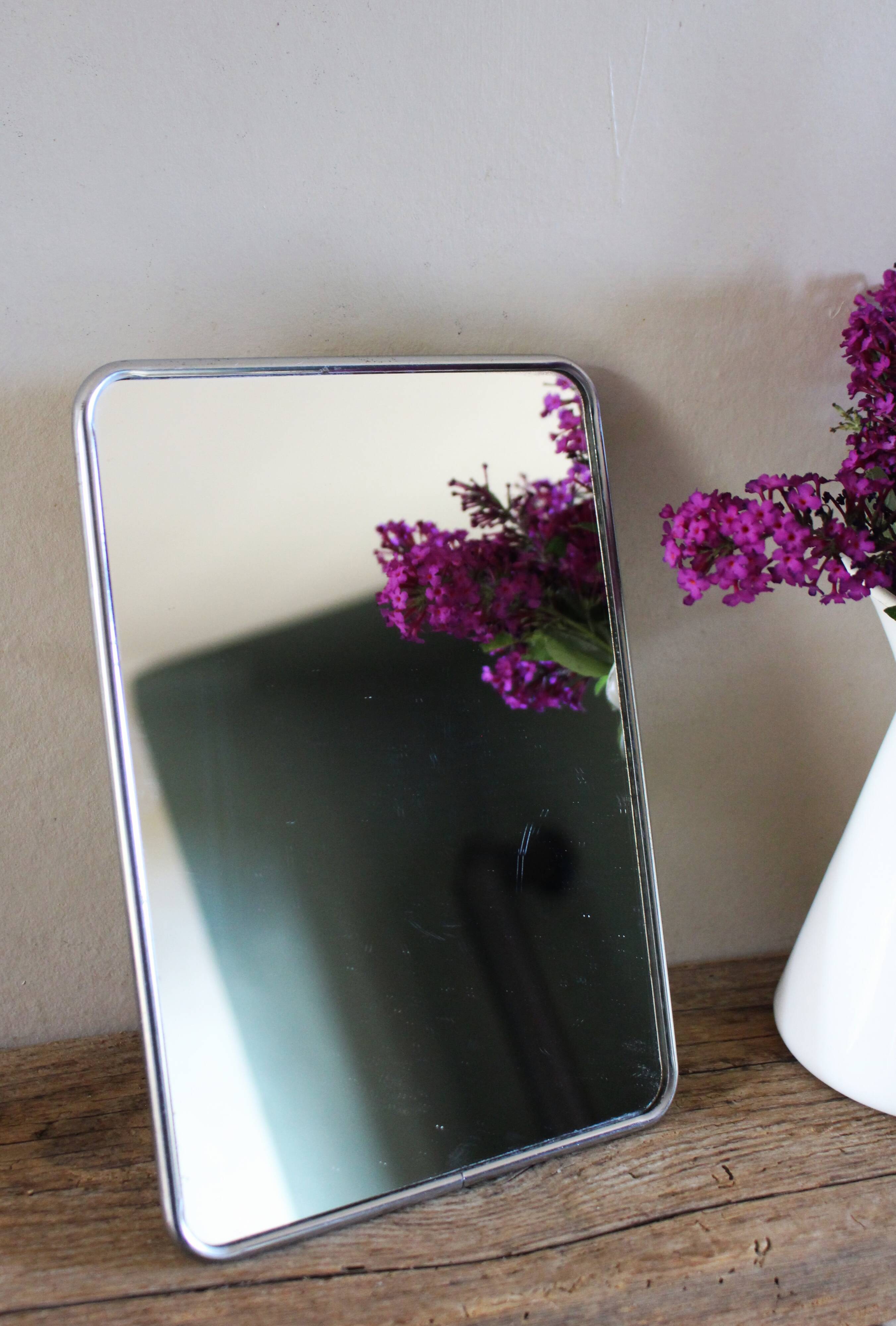 Simple rectangular barber mirror with a stand.