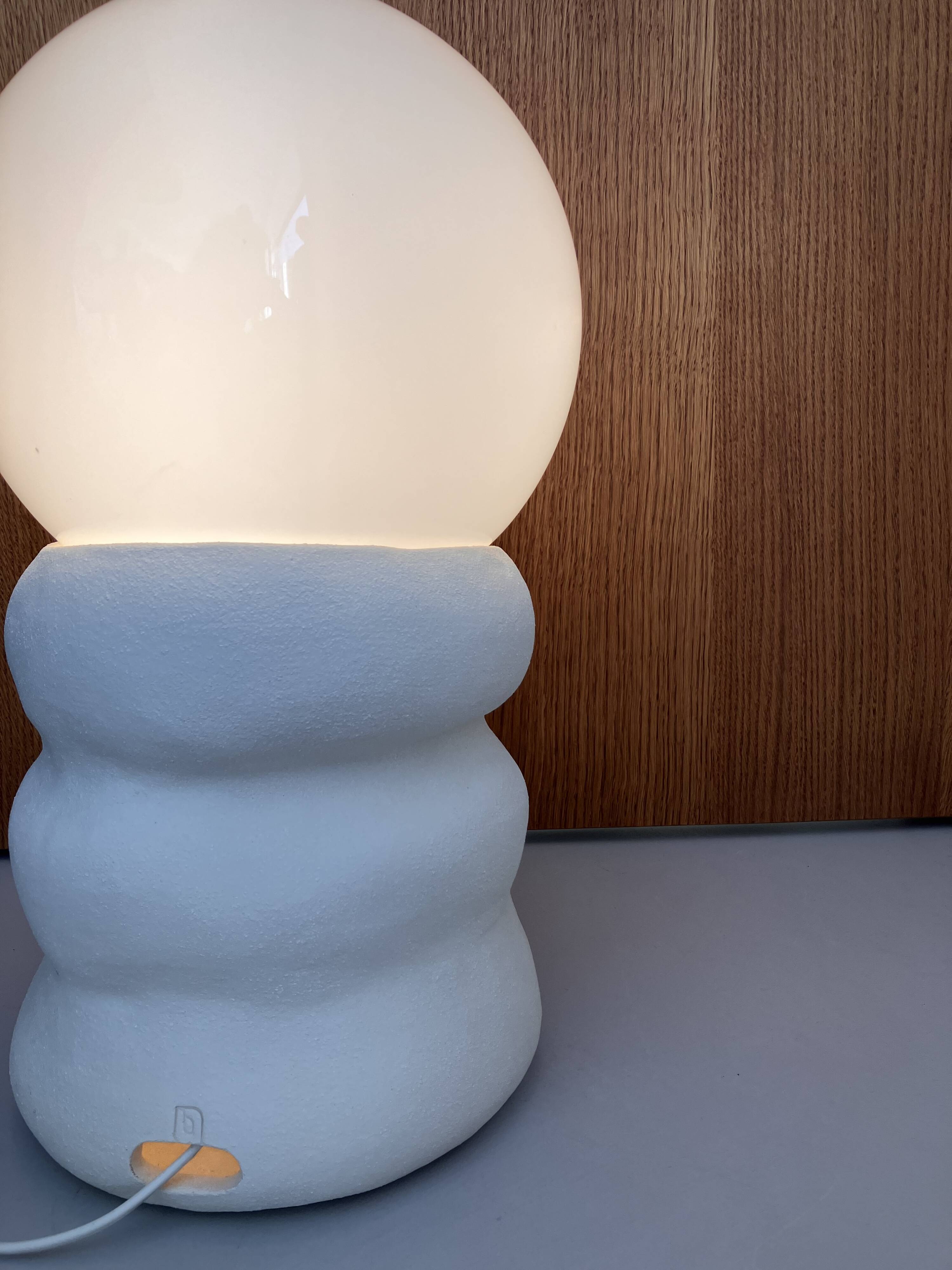 Large table lamp in off-white ceramic with an organic globe shape.
