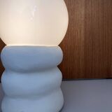 Large table lamp in off-white ceramic with an organic globe shape.