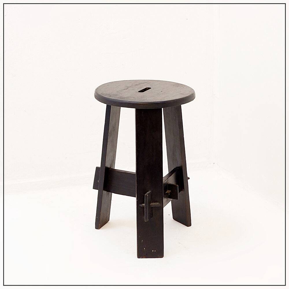 Vintage black-stained wooden tripod stool with mortise joints.