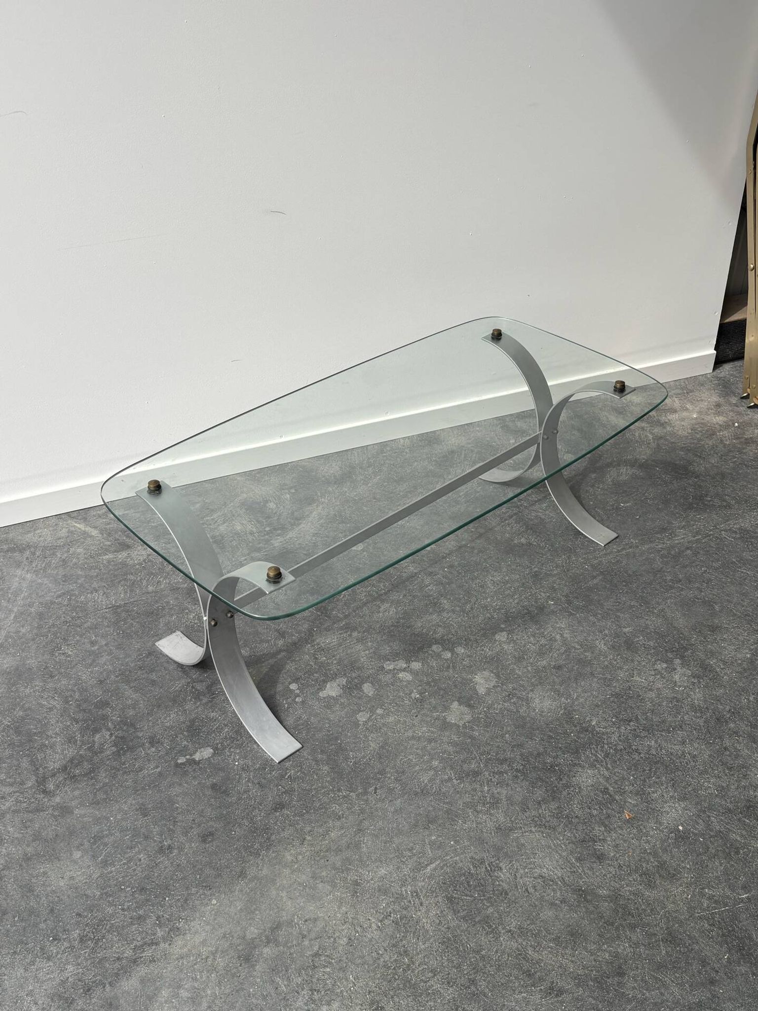 Design coffee table in brushed metal with a glass top, 1970s.