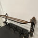 Large antique wall-mounted coat rack in wrought iron.