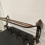 Large antique wall-mounted coat rack in wrought iron.