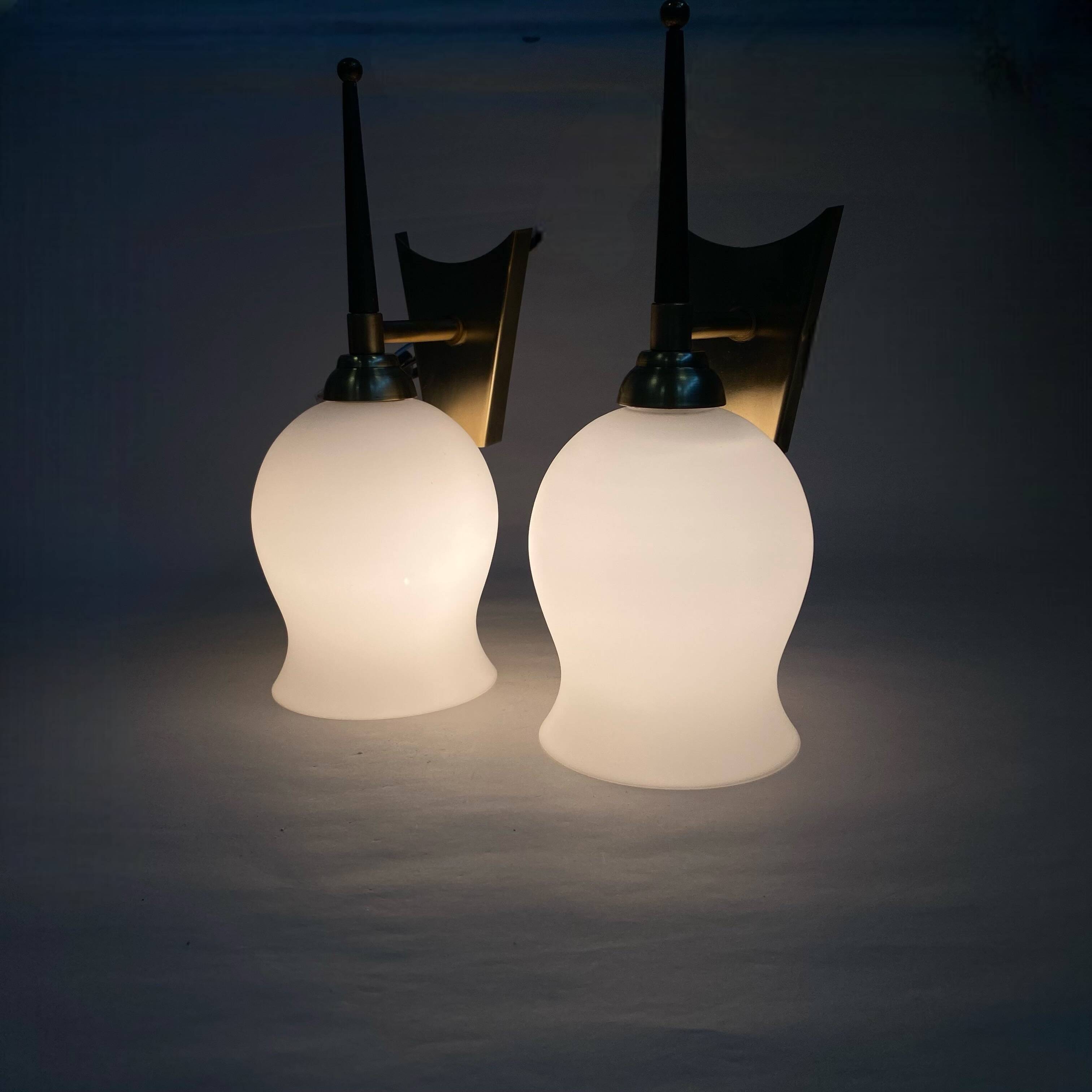 Pair of torch wall lights in brass, white glass and porcelain.