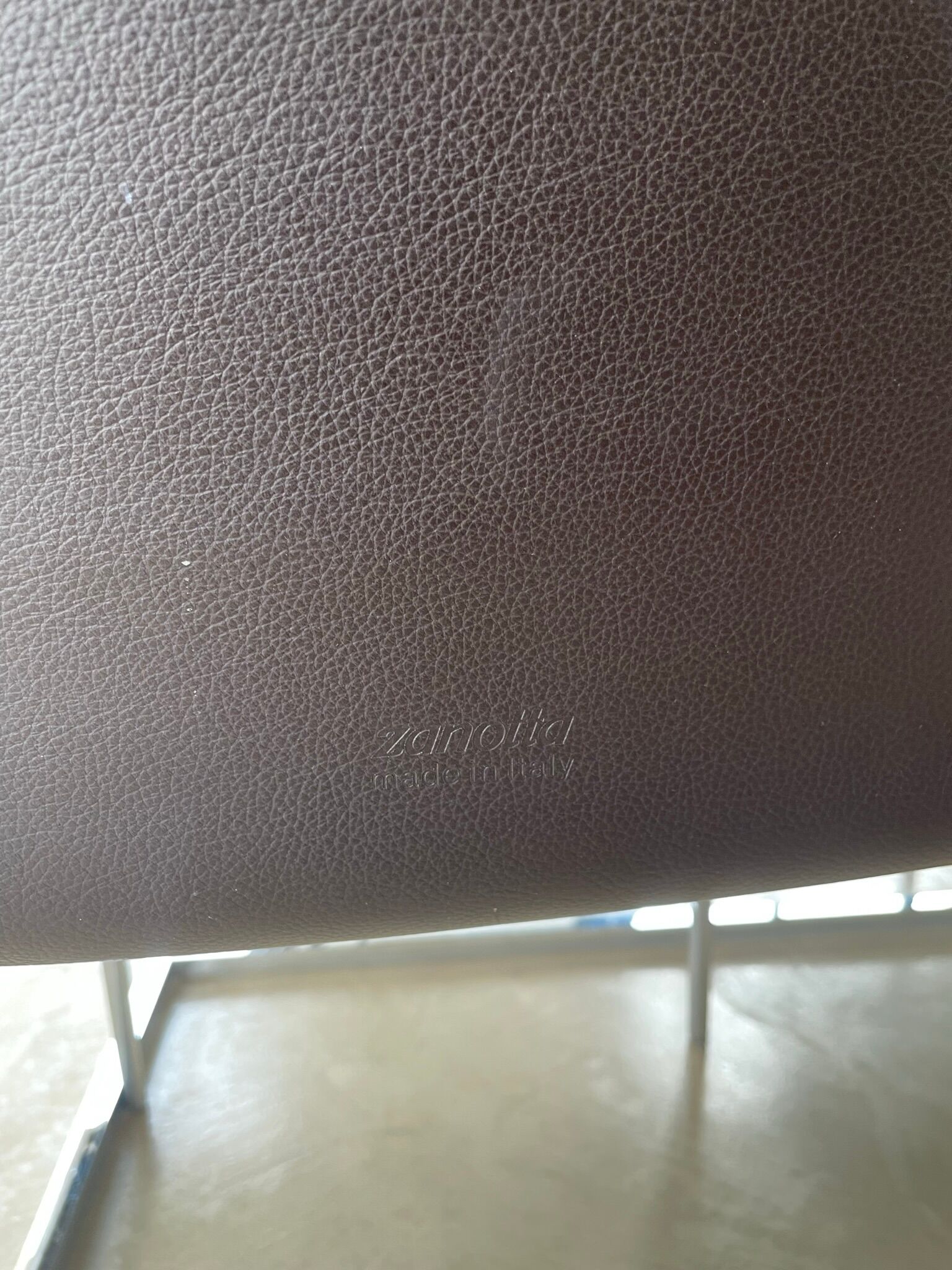 Brown leather chairs and Zanotta metal legs