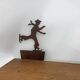 Wall shelf in wood and metal with a decoration of ice skaters.