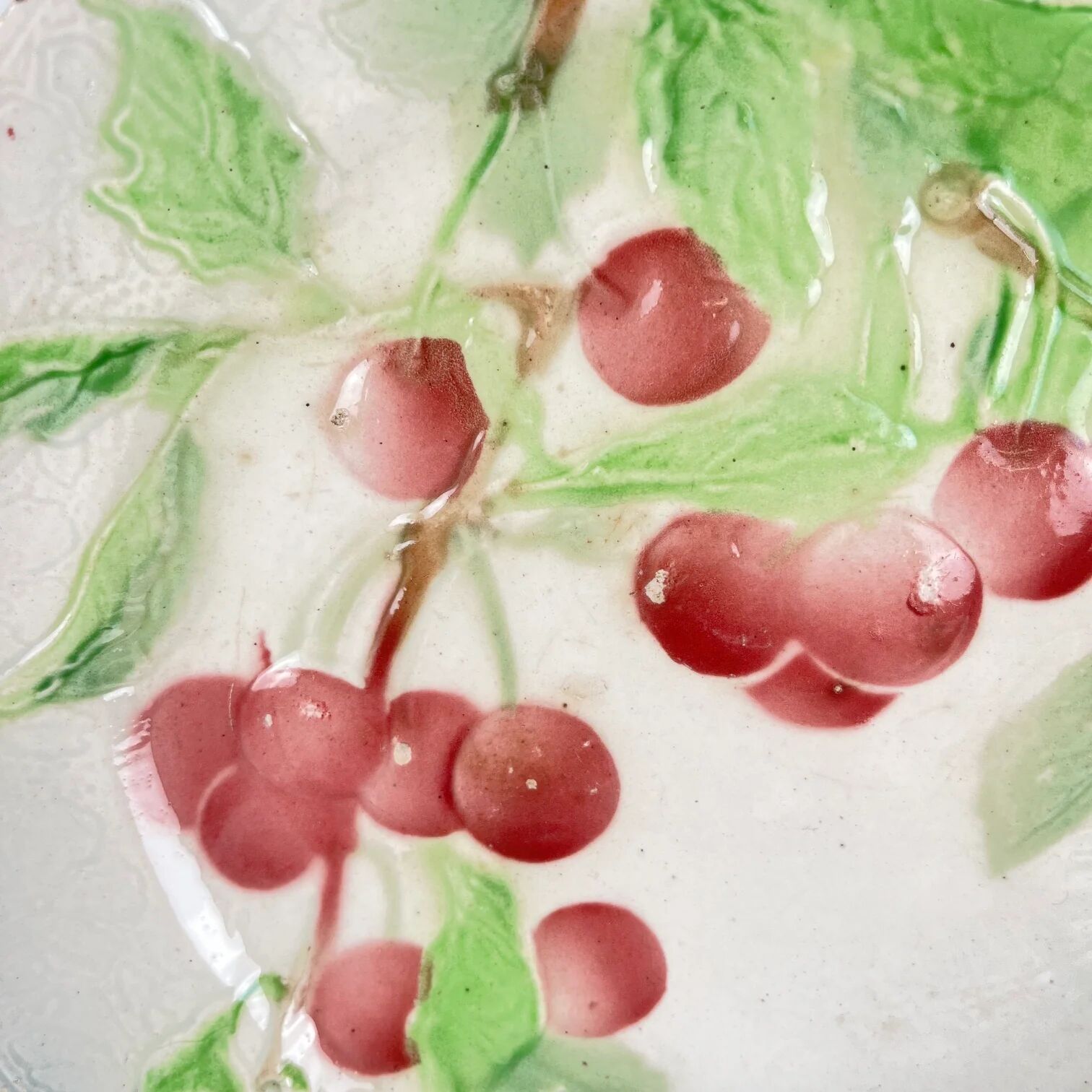 Set of 4 plates KG St Clément barbotine fruit (cherry, mirabelle, grape, pear), late 19th-early 20th century.