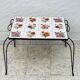 Vintage coffee table in wrought iron with floral tiles.