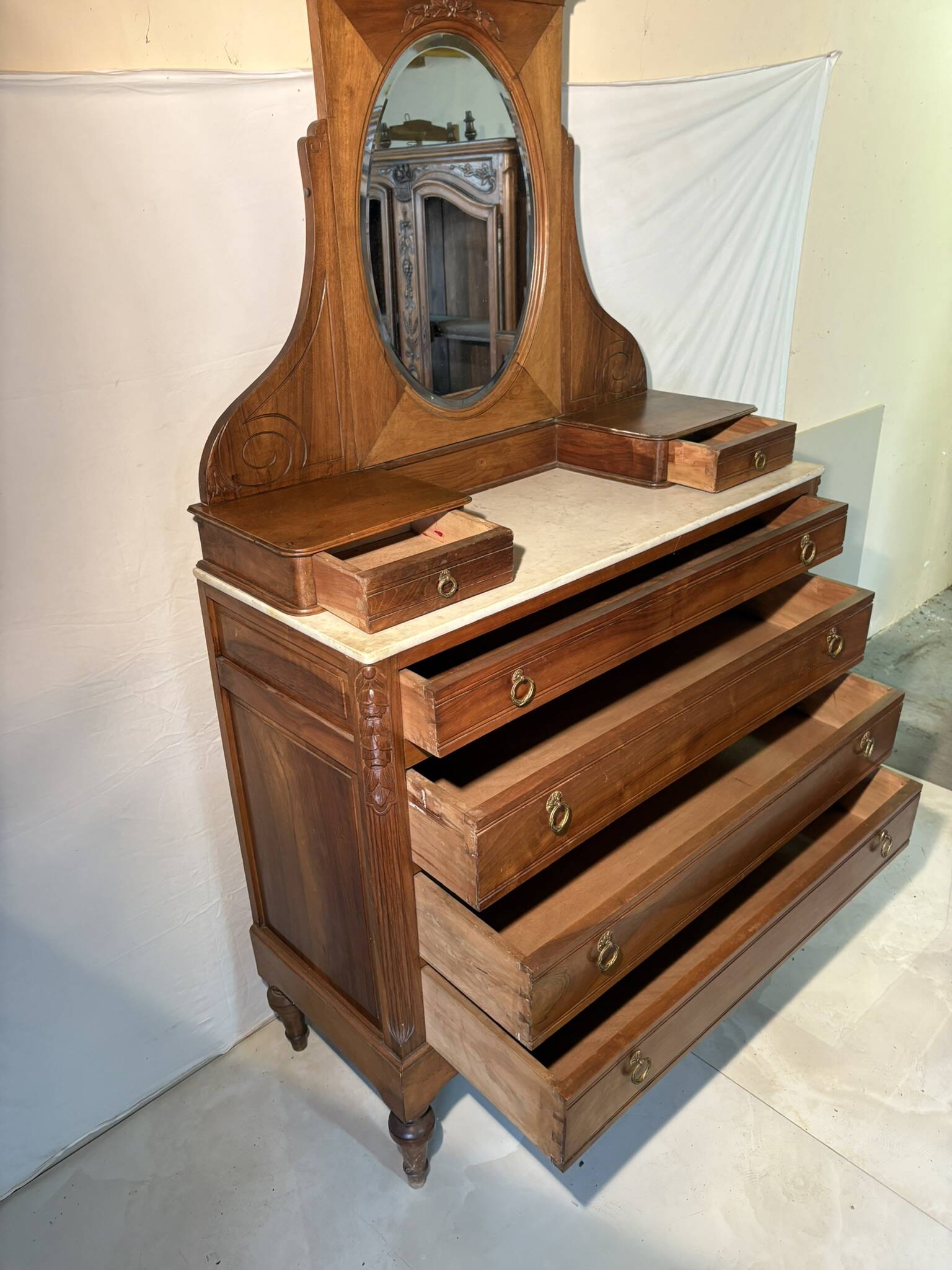 Antique carved wooden dressing table with marble and tilting oval mirror.