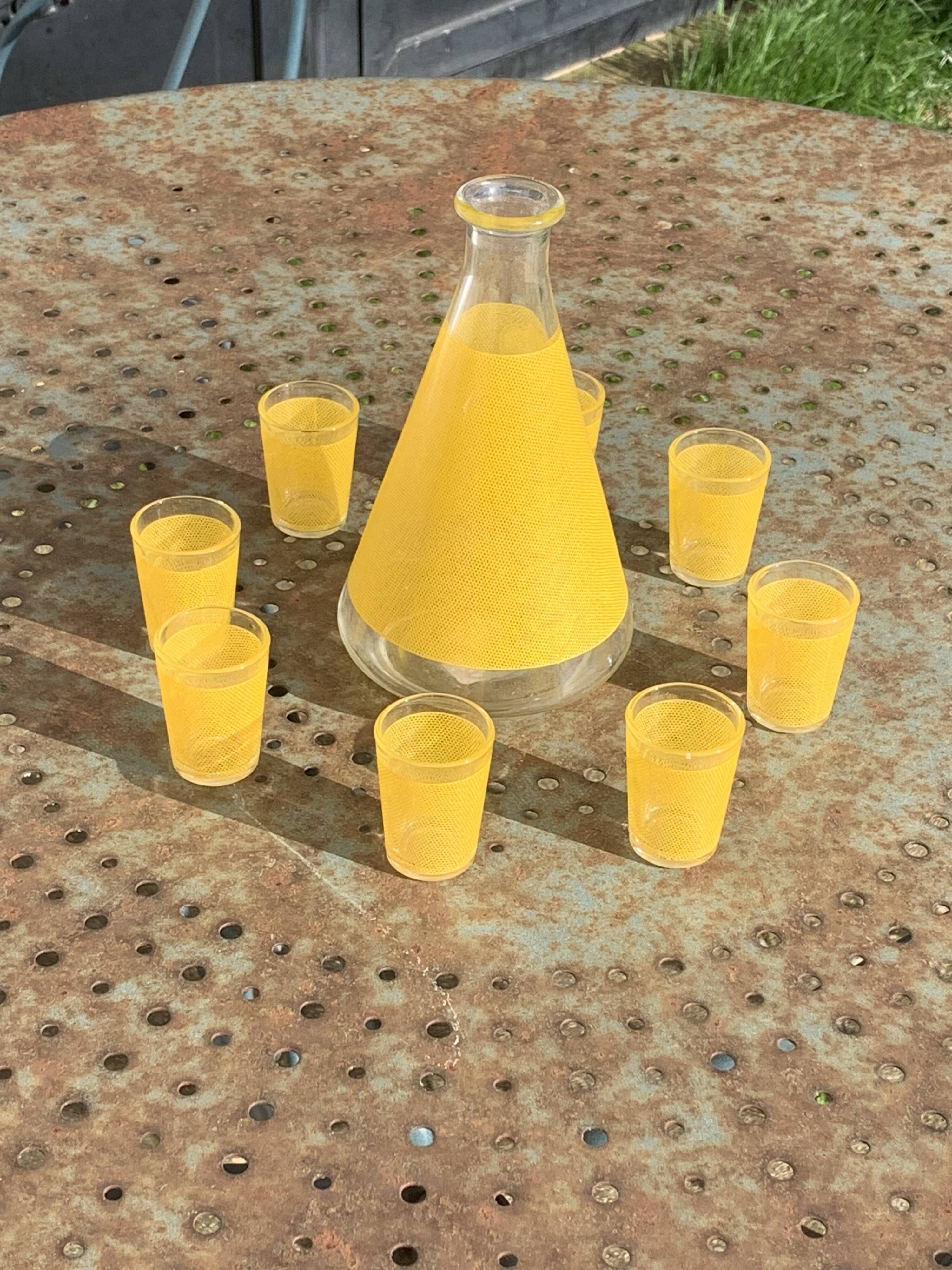 Liqueur service composed of a glass carafe and 8 small yellow screen-printed glasses