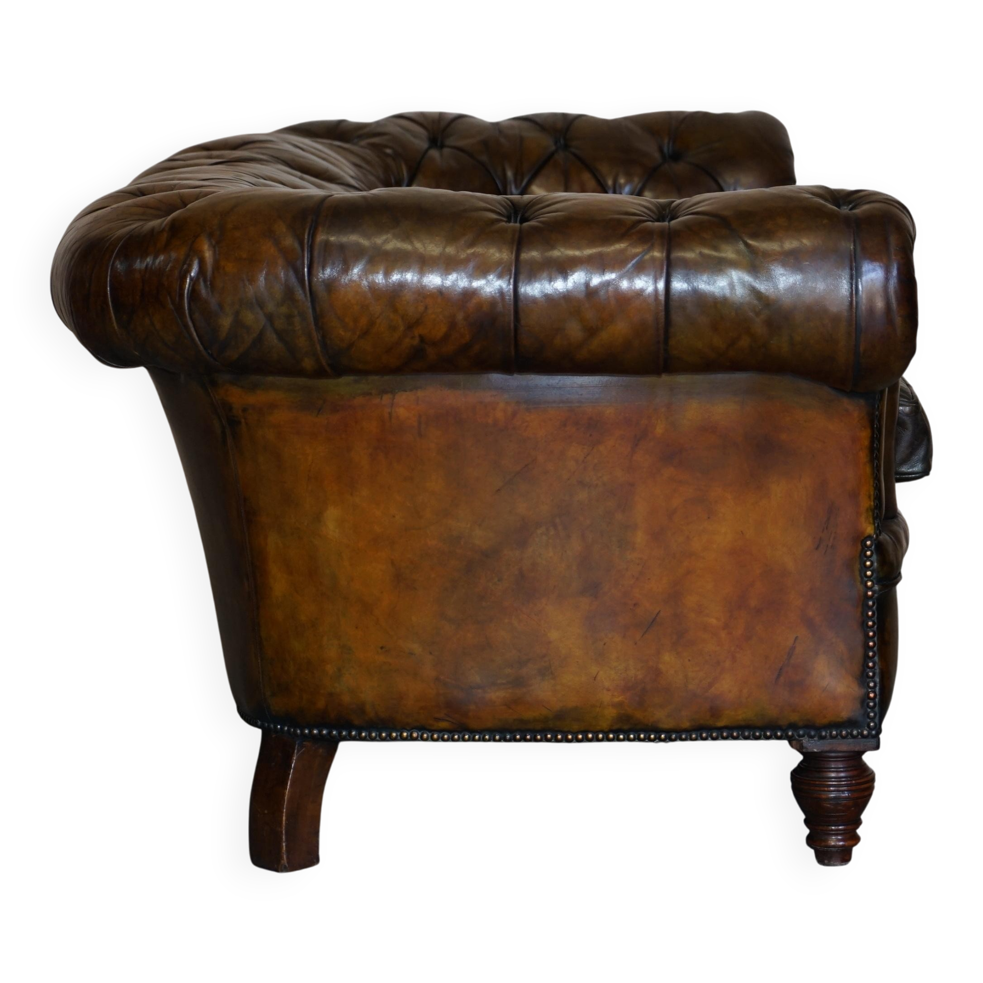 Victorian Chesterfield leather upholstered canapé with feather cushions.