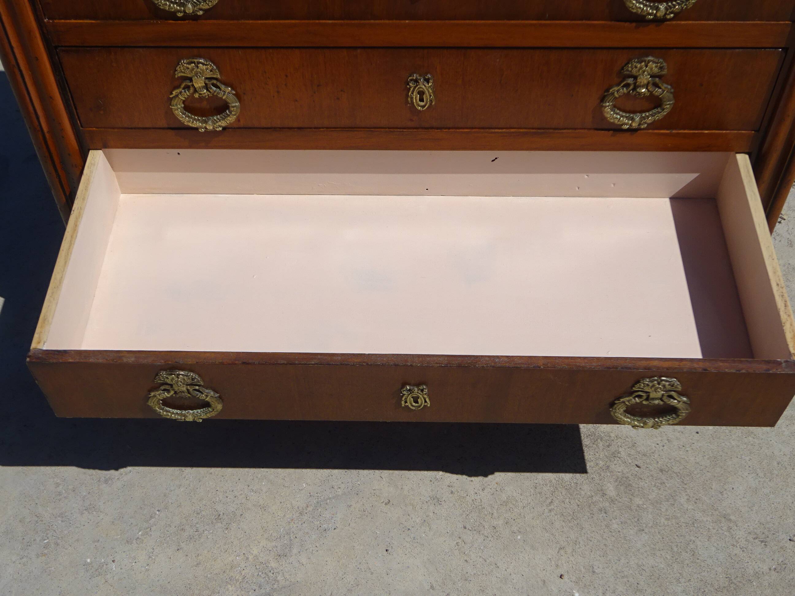 Chest of drawers with decorated handles in the Louis XVI style.