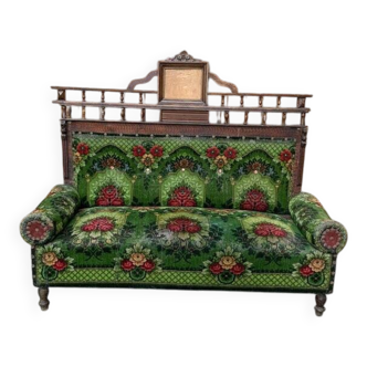 Two-seater canapé in green fabric with floral patterns and carved wood, late 19th century.