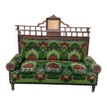 Two-seater canapé in green fabric with floral patterns and carved wood, late 19th century.