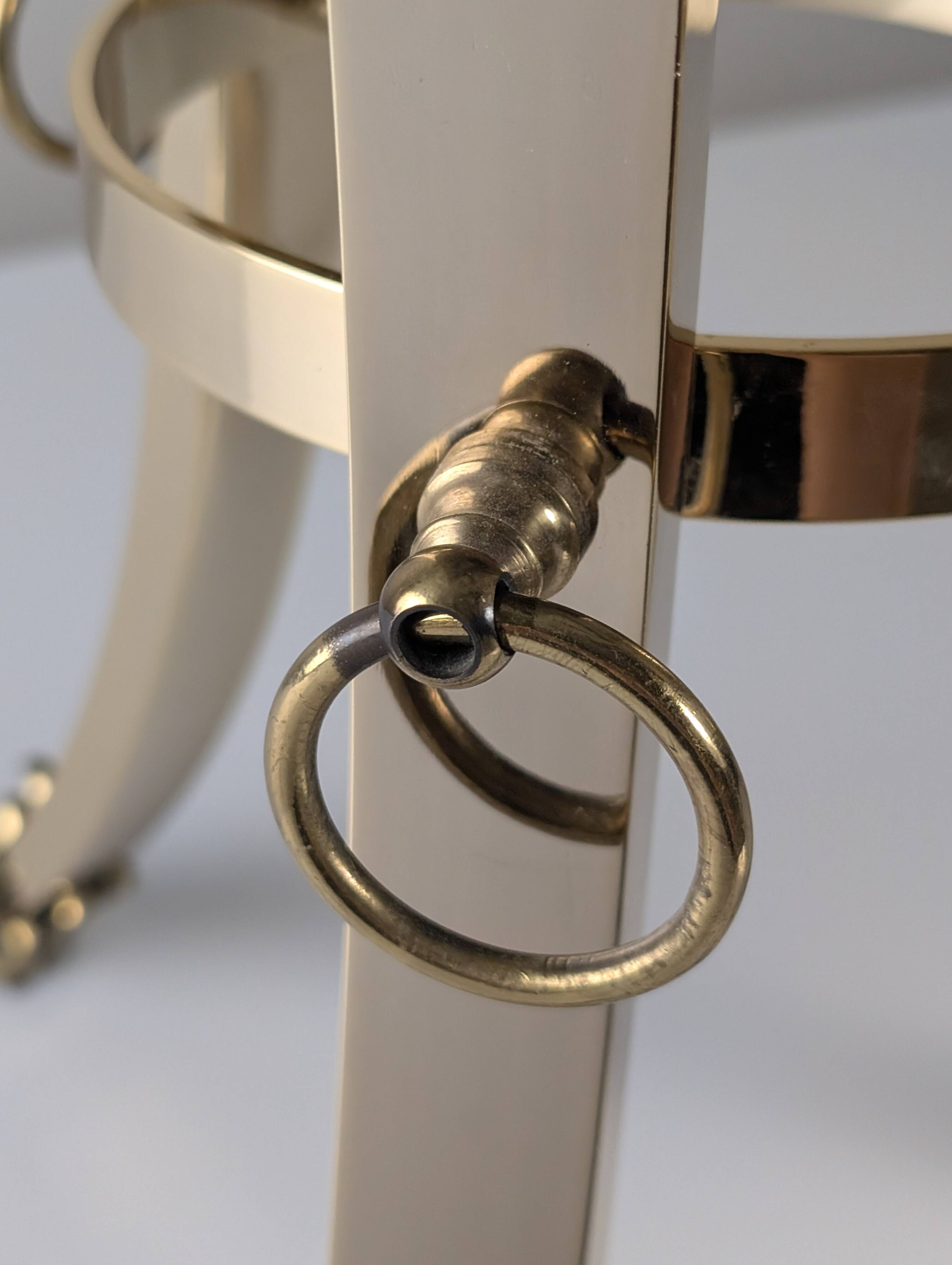 Neoclassical side table in brass and bevelled glass with ram's heads, 1970s.