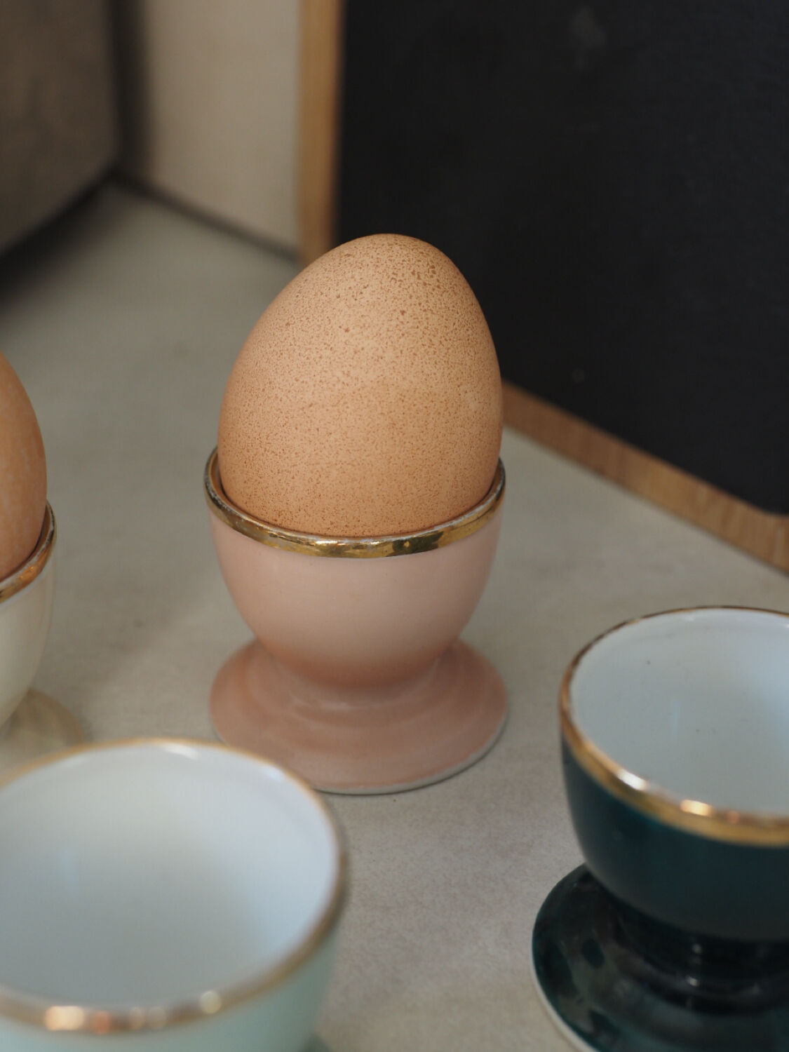 Four coloured egg cups with a golden rim from the 50s.