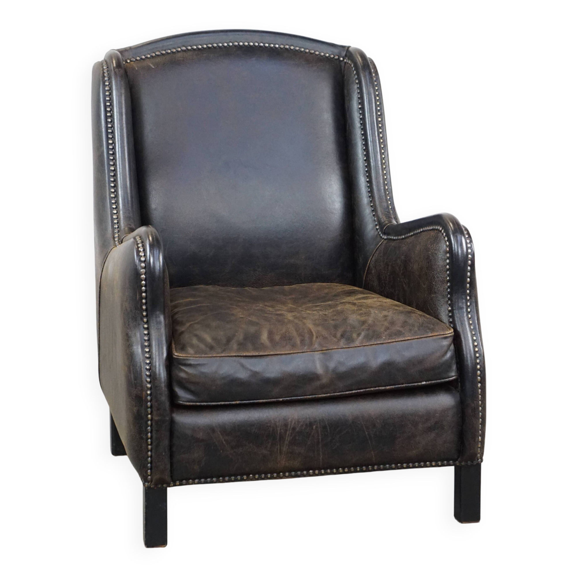 Black cow leather armchair in industrial style finished with decorative nails