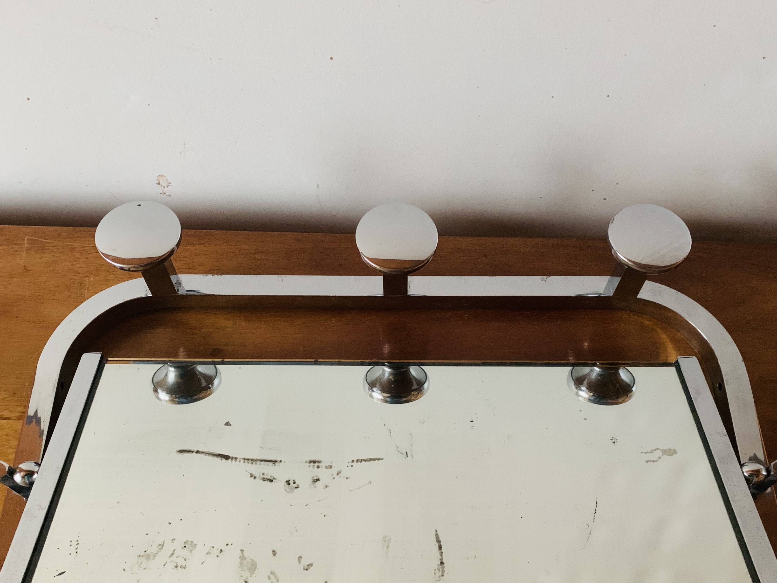 Vintage wall-mounted coat rack in chrome metal with integrated mirror and hat rack