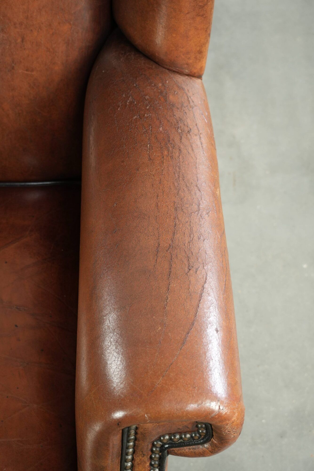 Sheepskin wingback armchair finished with black piping and a correct seat
