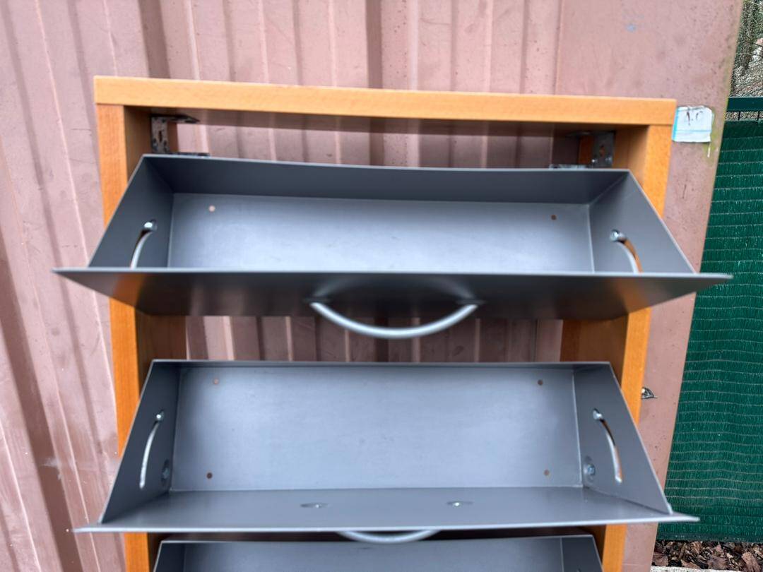 Scandinavian shoe storage cabinet in grey wood and metal.