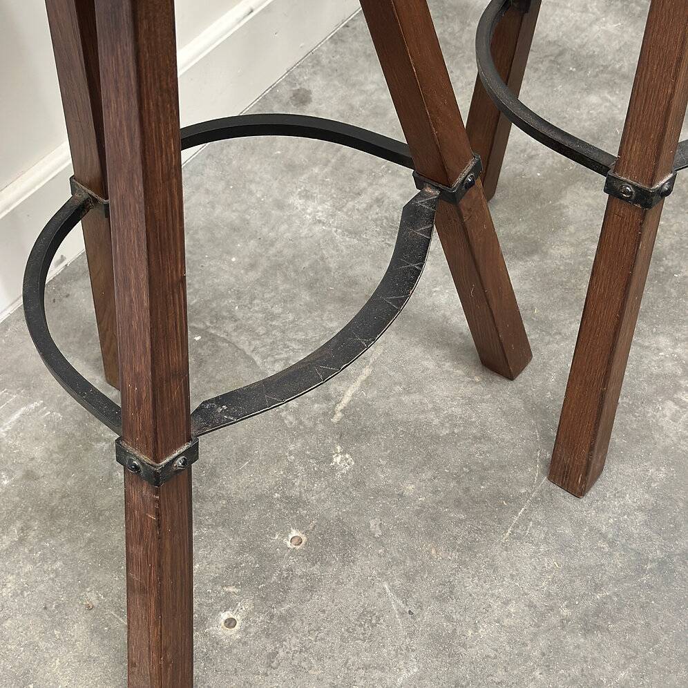 Set of 3 rustic carved oak bar stools with iron footrests, 1970s