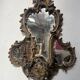 Mirror with a decorative frame featuring a four-light wall sconce, 19th century.