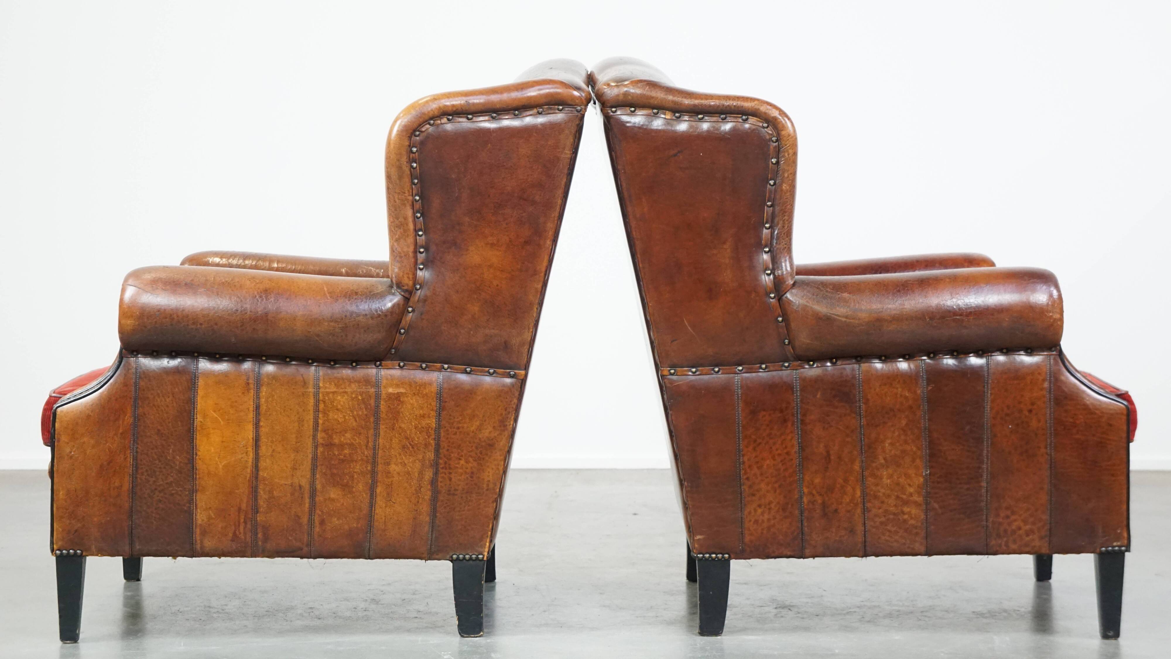Set of 2 sheep leather wingback chairs with red corduroy seat cushions
