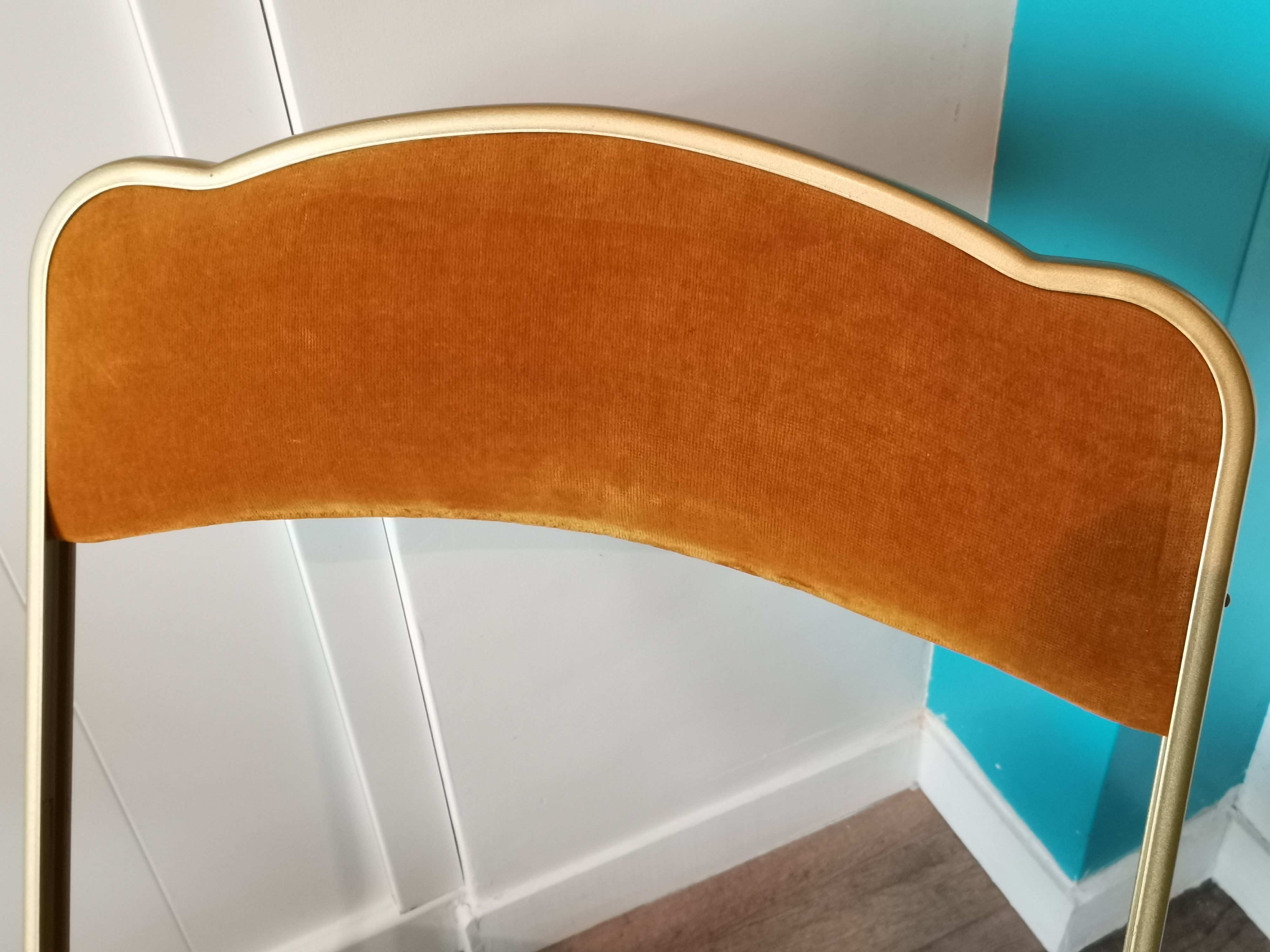 Two gold velvet folding chairs