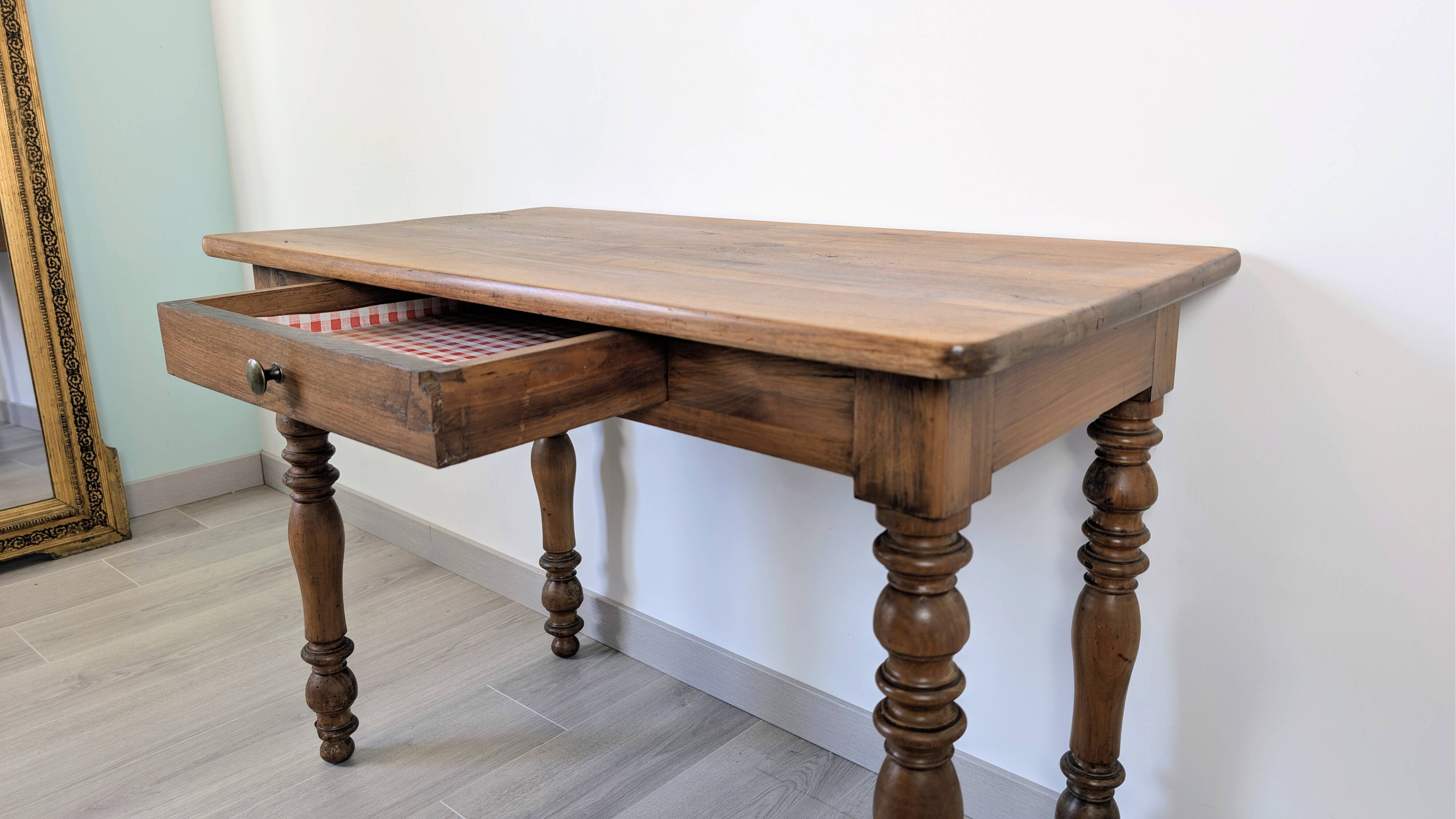 Antique writing table in the Napoleon III style with turned wooden legs.