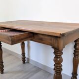 Antique writing table in the Napoleon III style with turned wooden legs.
