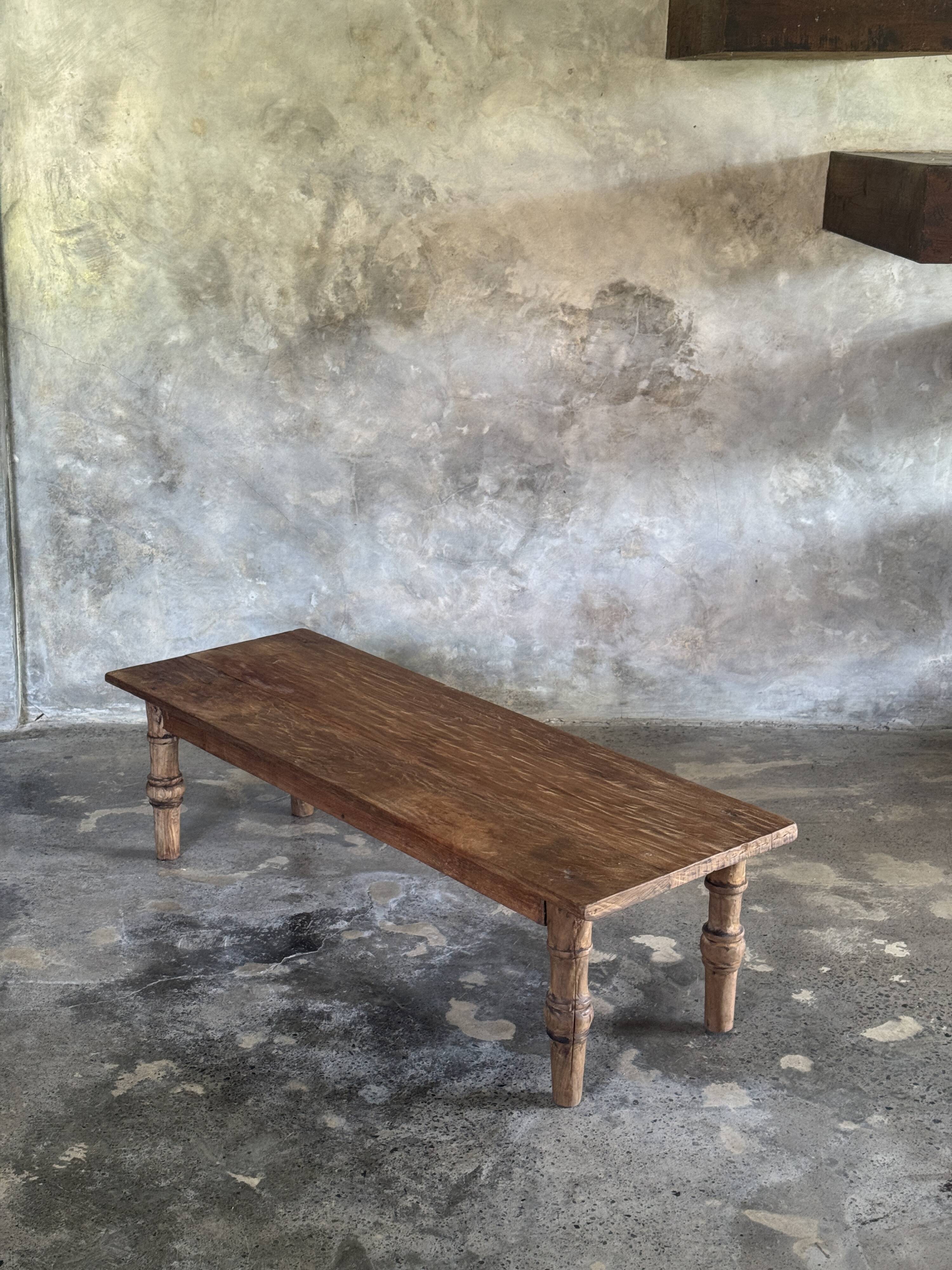 Brown Indonesian teak coffee table, with a border and cylindrical legs H40 L103.