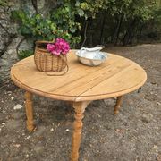 Folding drop-leaf table made of raw solid wood.