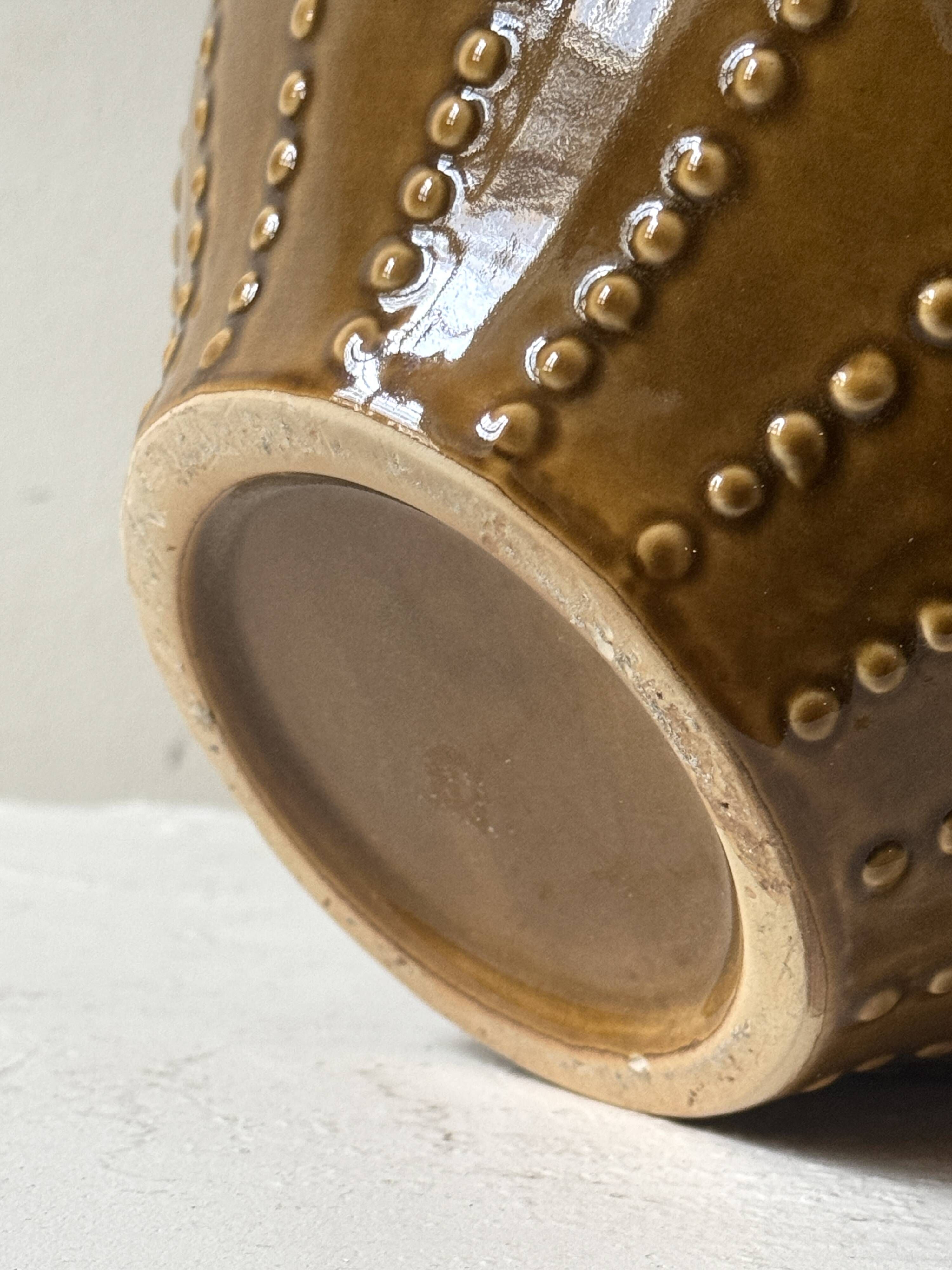 Pyriform vase in glazed ochre ceramic and beads.