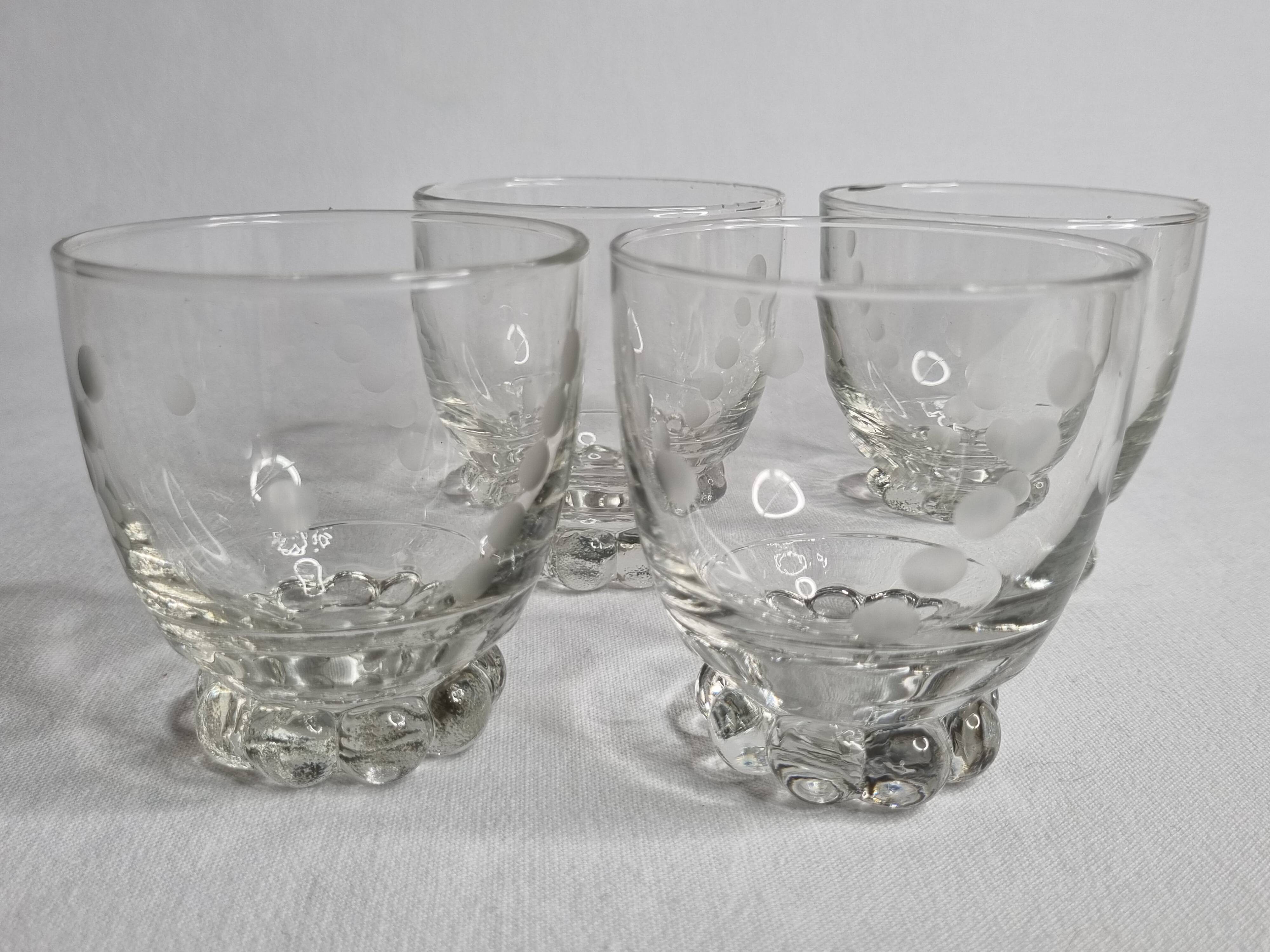 Set of four Art Deco style engraved crystal glasses on spherical feet