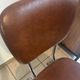 Two brown faux leather chairs.
