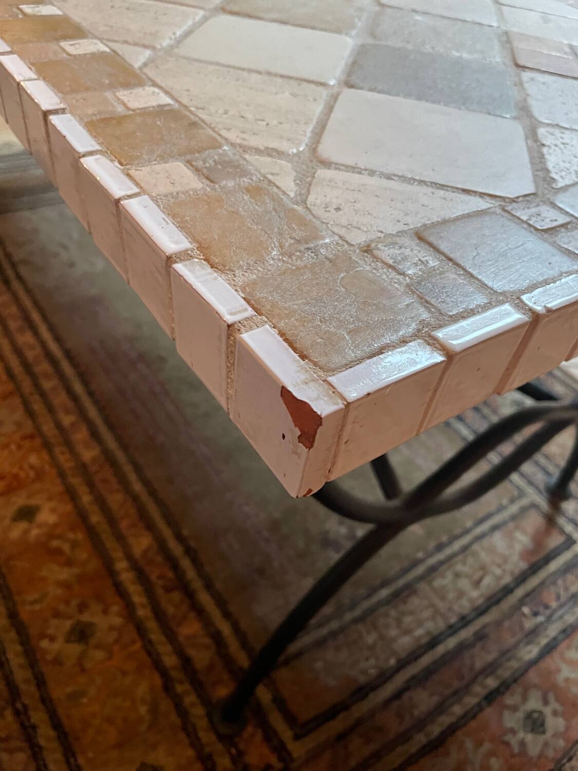 Beige ceramic coffee table with black metal legs.
