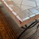 Beige ceramic coffee table with black metal legs.