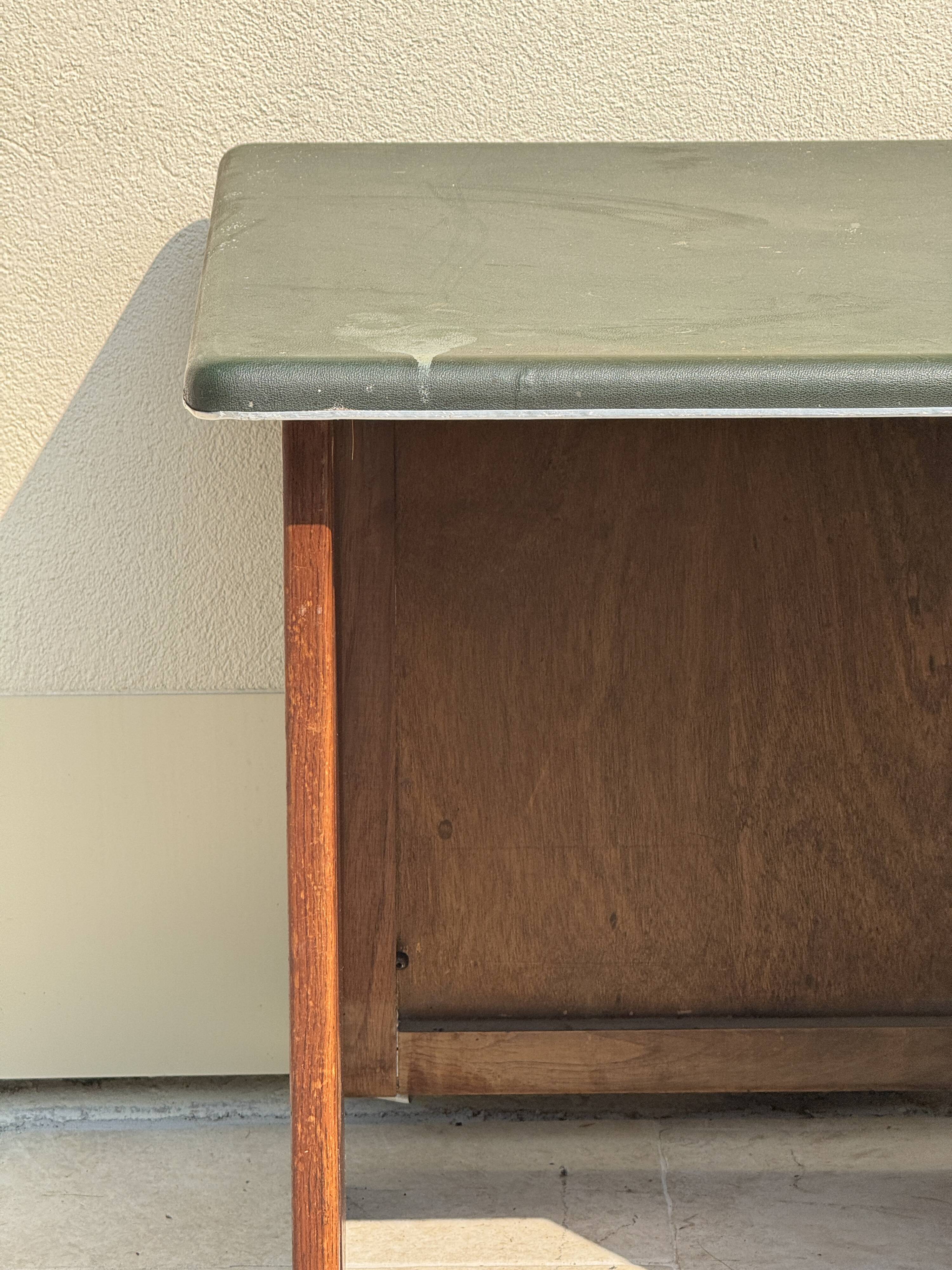Modernist desk in wood and green moleskin upholstery