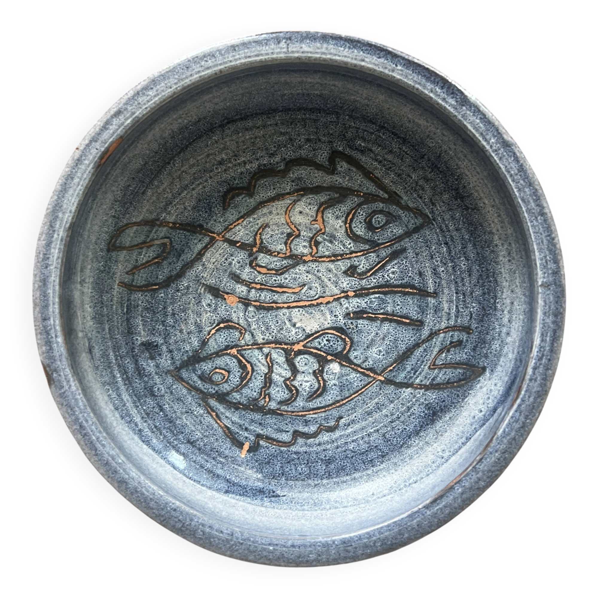 Glazed blue ceramic bowl with stylised fish decoration.