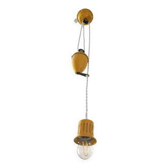 Suspension rises and falls in yellow painted metal