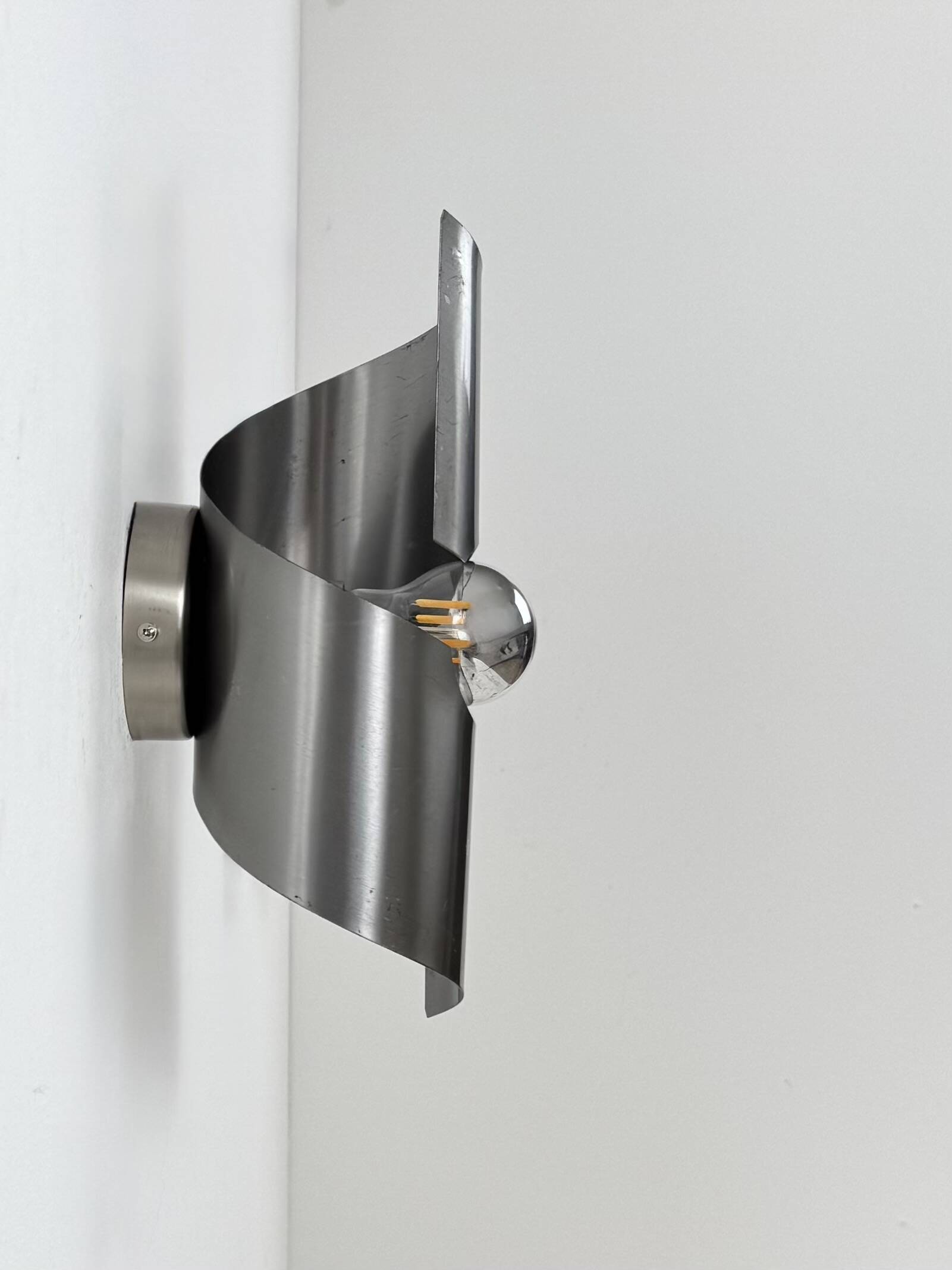 Pair of vintage wall lights, curved patinated steel, France, 1970.