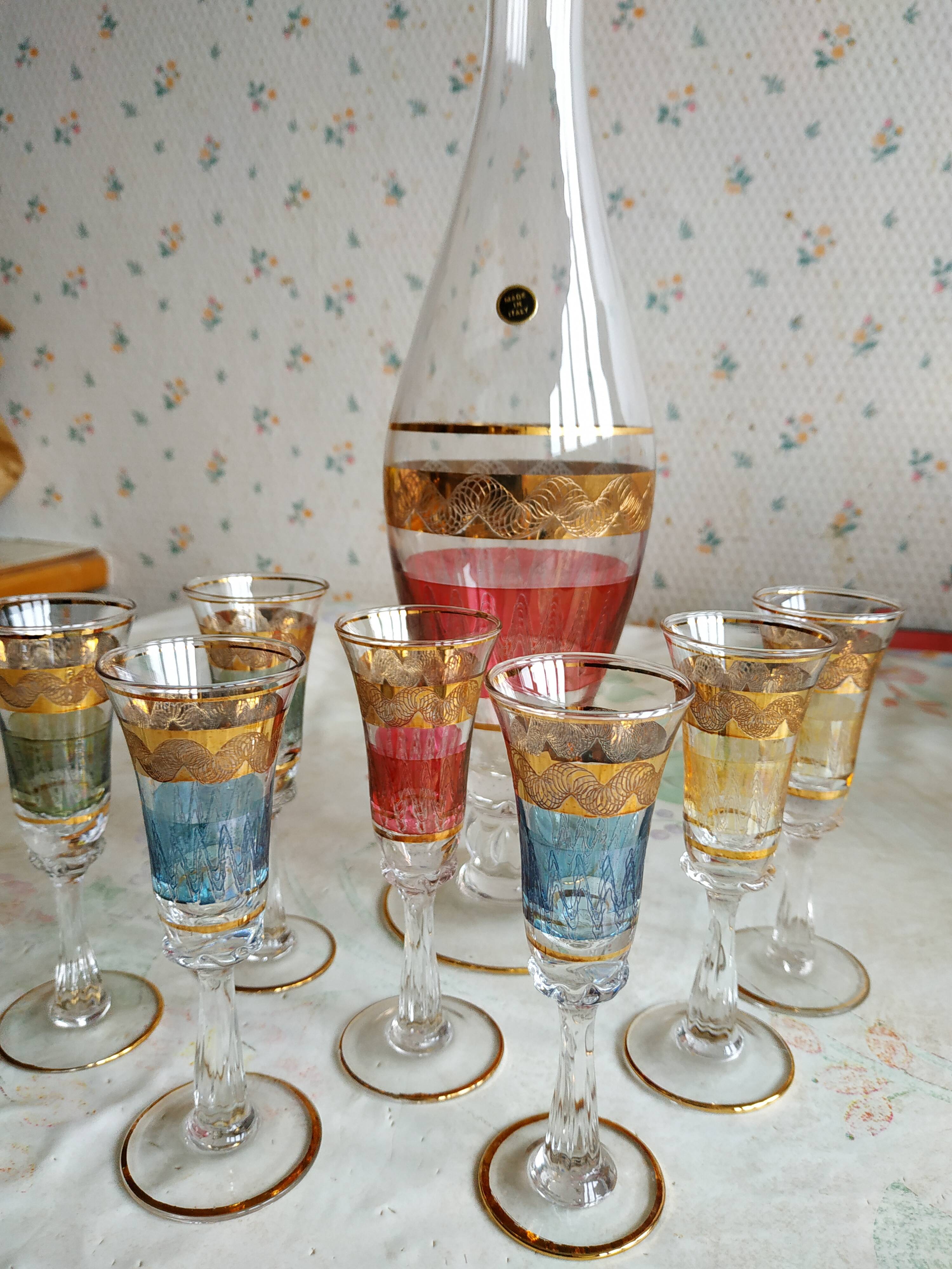 Liqueur set, colored and golden glasses and carafe