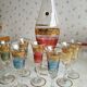 Liqueur set, colored and golden glasses and carafe