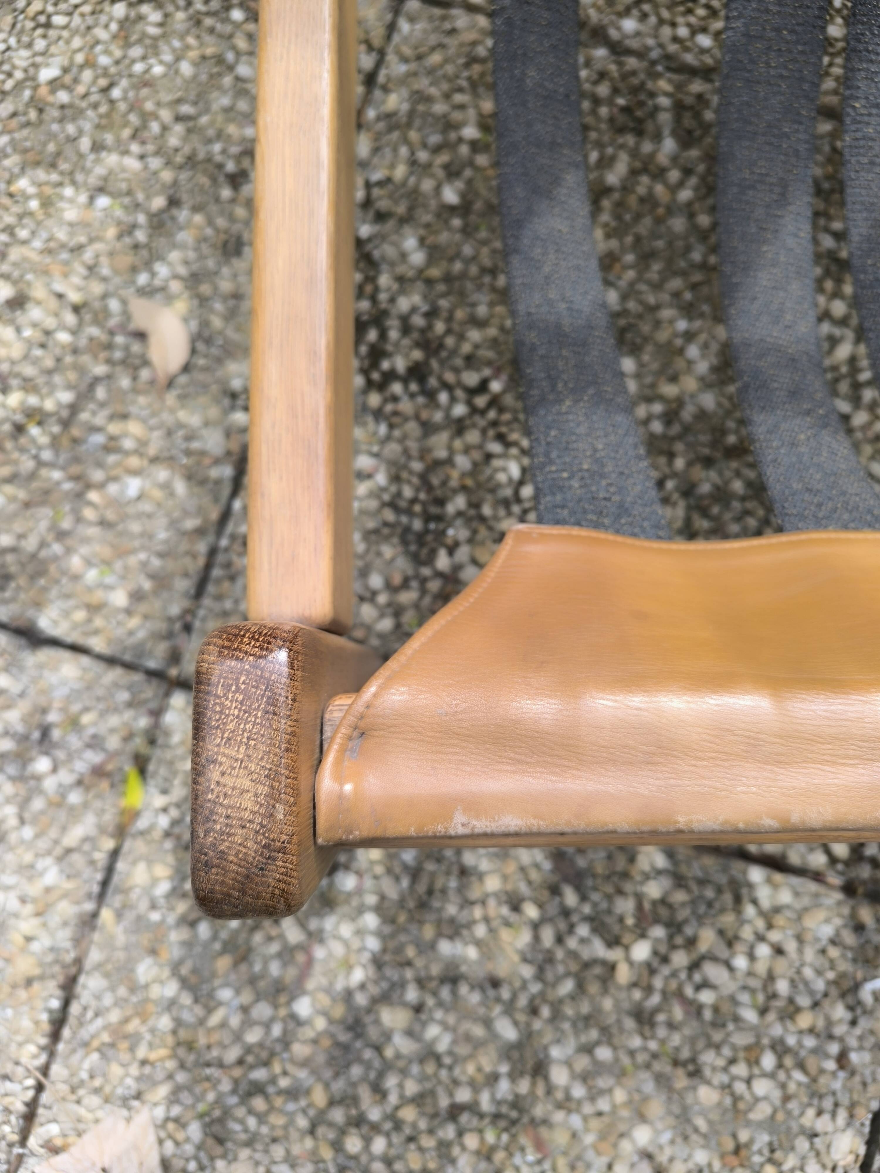 Pair of solid wood and leather lounge chairs, European work, circa 1970.
