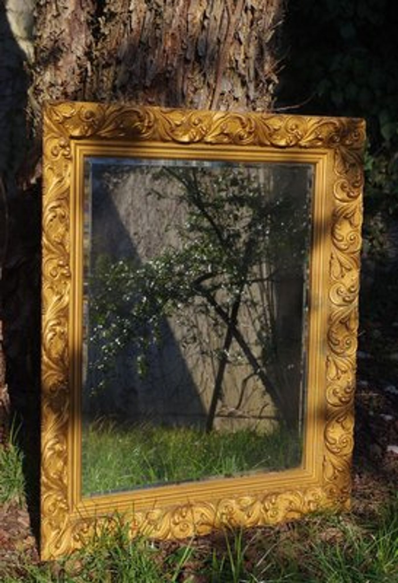 Wooden mirror decorated with gold from the 1920s