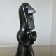 Matte black ceramic sculpture representing a female tribal figure.