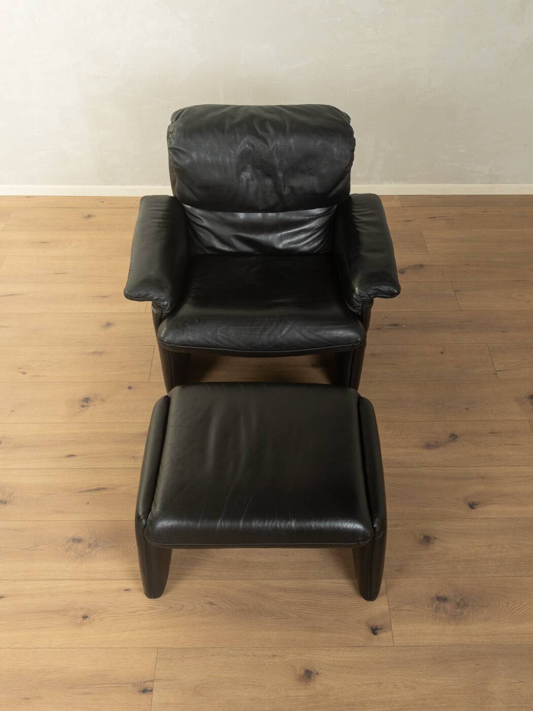 1980s cor armchair and ottoman in black leather